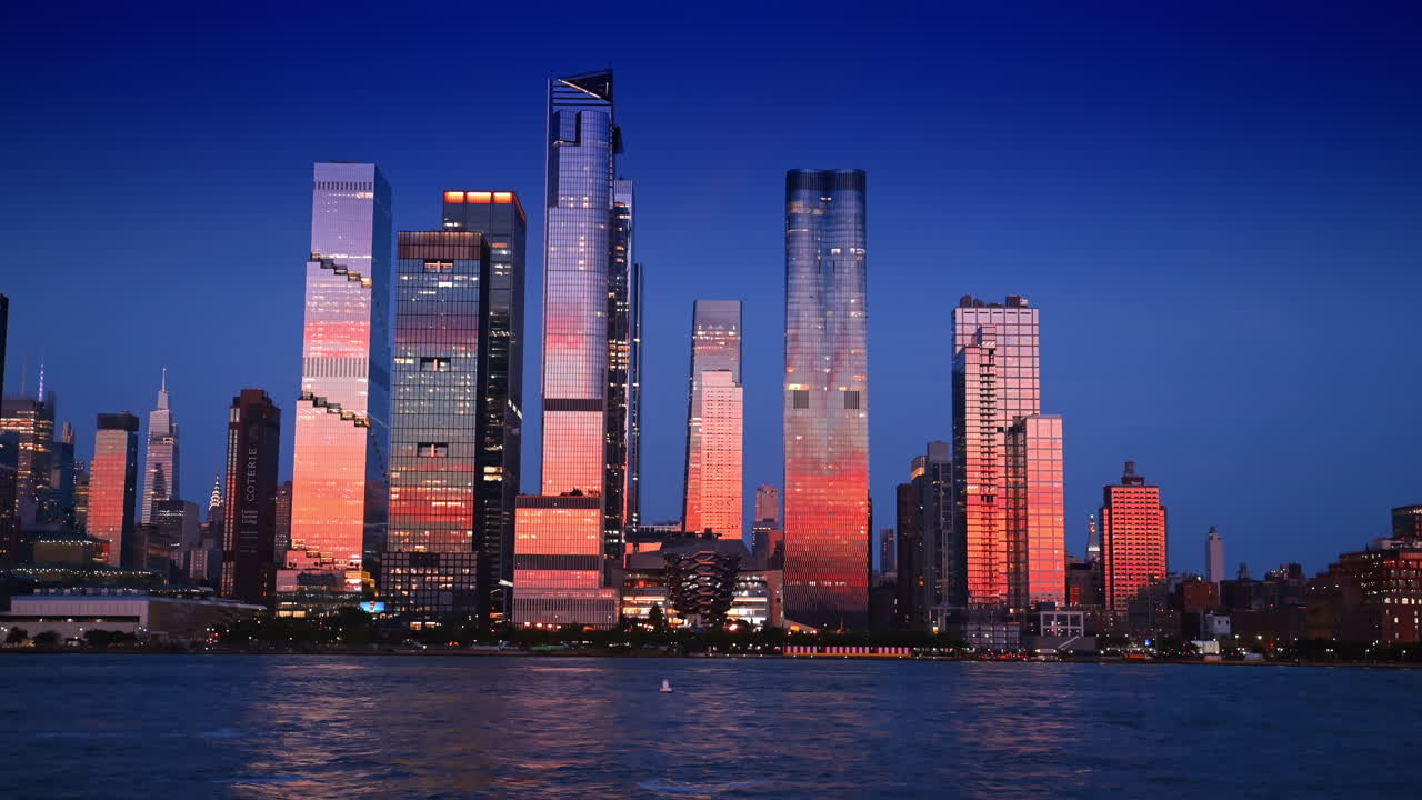 Fantastic buildings of New York, USA colored in pink light at sunset time. View on the skyline of Manhattan and Vessel Sculpture from the riverscape