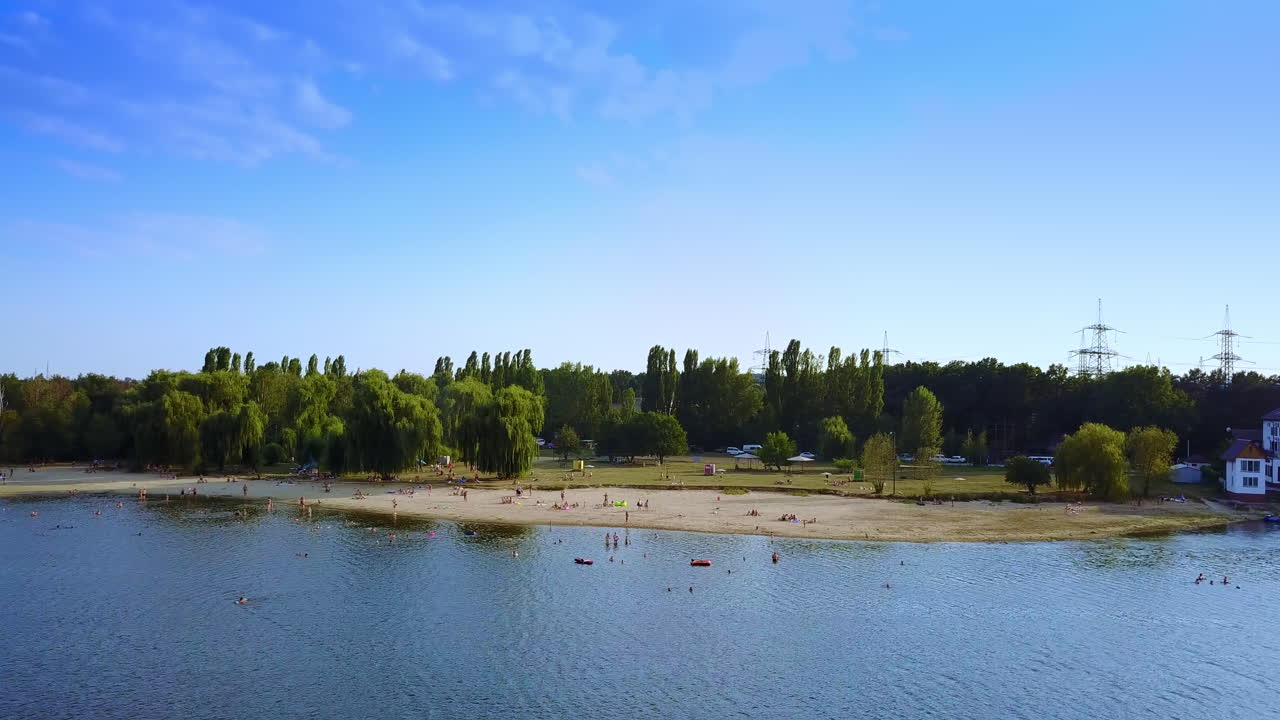 Søstrand med folk, der slapper af og nyder sommerdagen