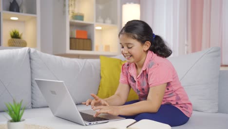 niña trabajando en una computadora portátil con expresión feliz.