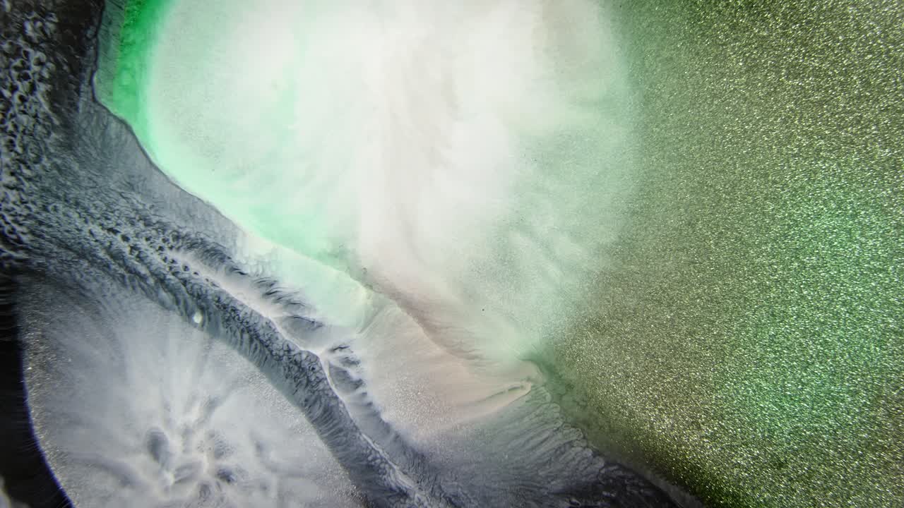difusión de tinta verde y blanca suave en el agua con partículas brillantes, creando una atmósfera de ensueño