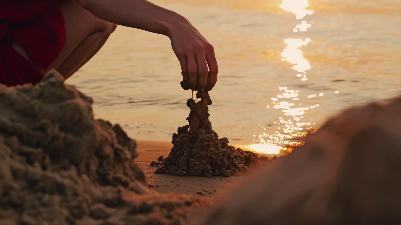 Baltic Sea waves, golden light frame woman’s hand shaping fleeting sand, slow mo
