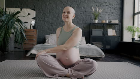 pregnant woman doing yoga in bedroom