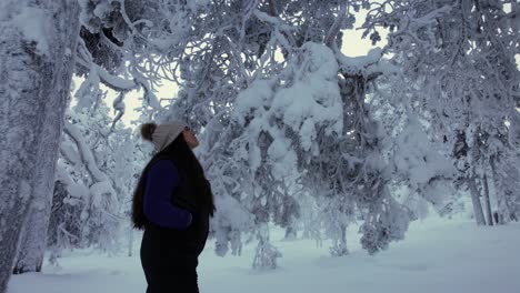 Hermosa-Joven-Explorando-Paisajes-En-Bosques-Nevados-En-Laponia,-Finlandia,-Círculo-ártico