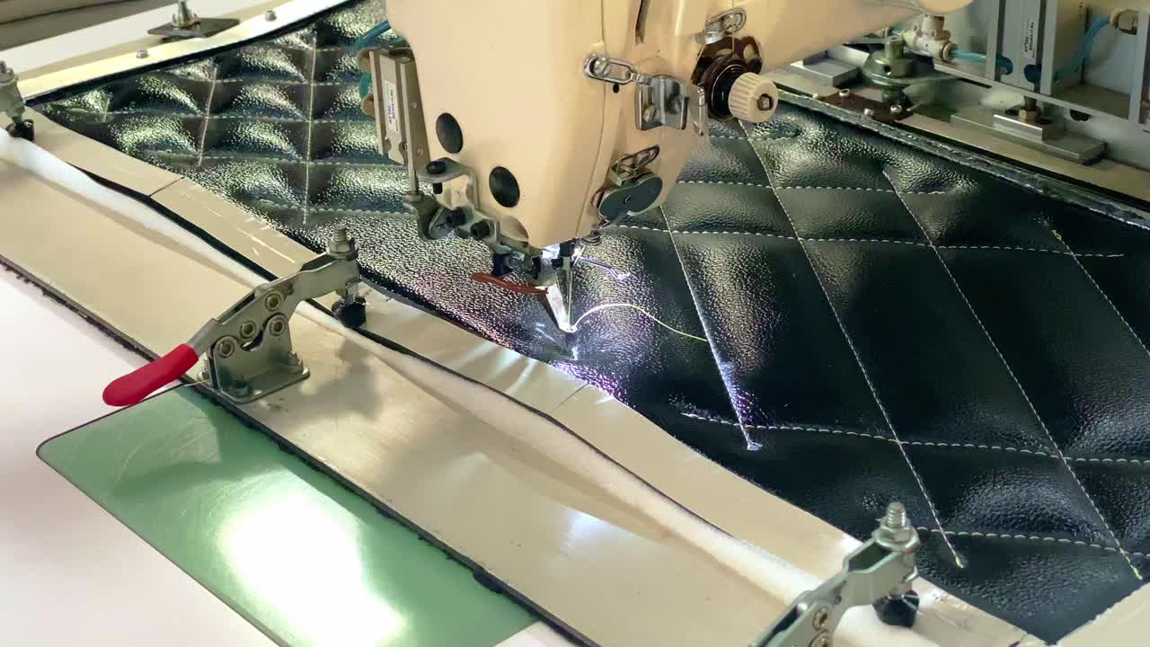 Hænder tråder en automatisk symaskine. Tekstilindustri