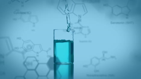 vaso de laboratorio cayendo con datos y fórmula estructural de compuestos químicos en primer plano
