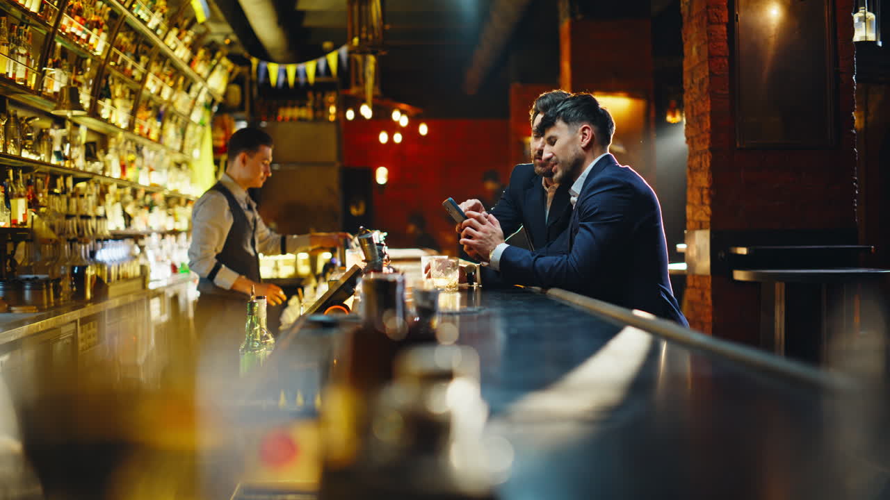 Gæster på en pub, der bruger smartphones til at diskutere indhold på sociale medier i en restaurant