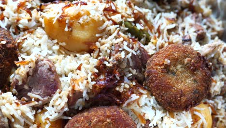 close-up of delicious biryani with meat and pakoras