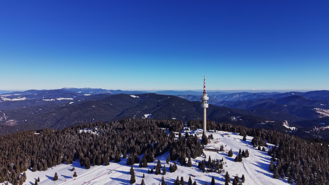 Zimní krajina v bulharských Karpatech s televizním vysílačem a kopci.
