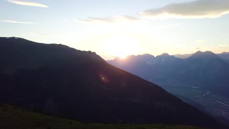 sunset on mountains over a valley with small city