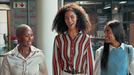 three smiling female colleagues in a modern office