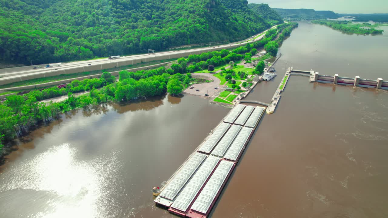 Overview aerial of barge boat passing through the lock and dam system near La Crescent, Minnesota, on the Mississippi River