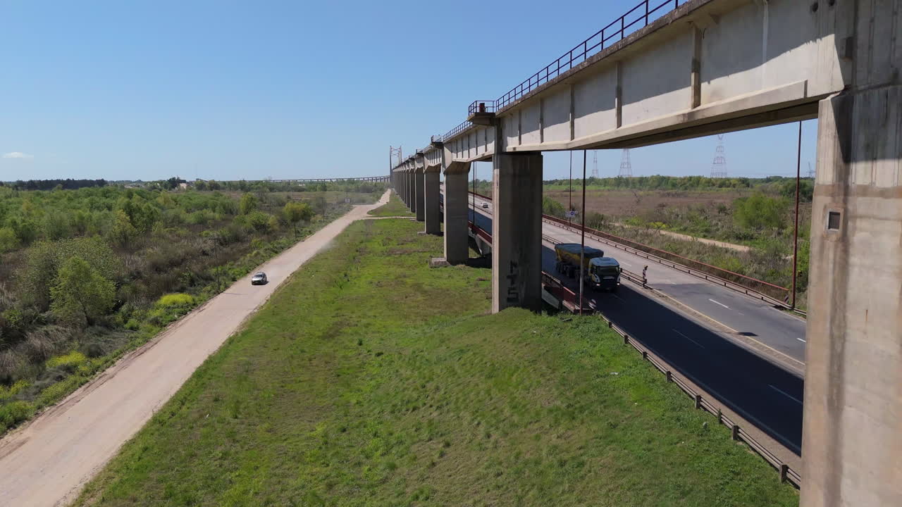 The justo josé de urquiza bridge over a road and river on a sunny day, aerial view
