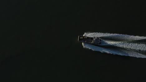 Scenic-aerial-directly-above-shot-of-motorboat-sailing-across-sea