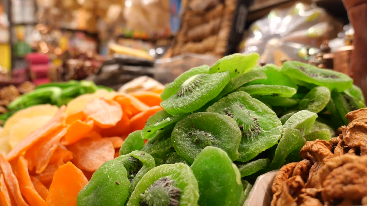 A vibrant display of dried kiwi and mango slices at a market