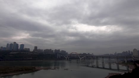 airplane leaving chongqing city with river and cityscape in background