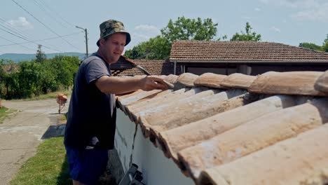 builder brush cleans cement from terracotta tiled wall work preparation