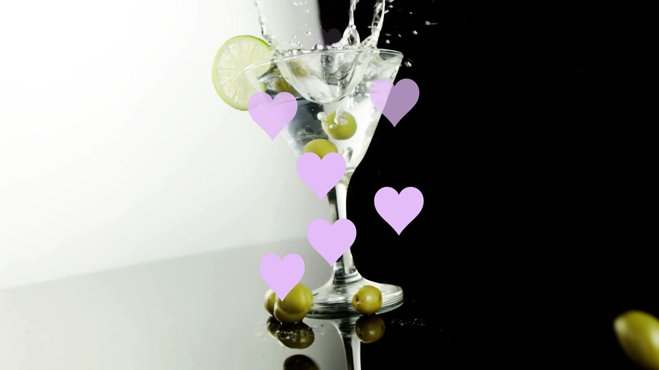 Animazione di cuori che fluttuano sopra un bicchiere di martini su sfondo nero.