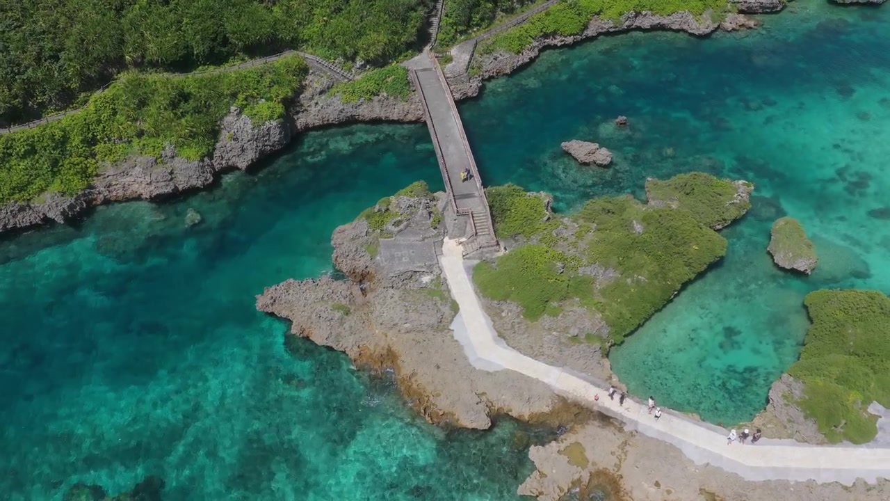 Rekaman udara horizontal miring ke bawah saat melakukan orbit lambat di atas Taman Laut Imgyaa dan Shigira, Miyakojima, Okinawa, Jepang
