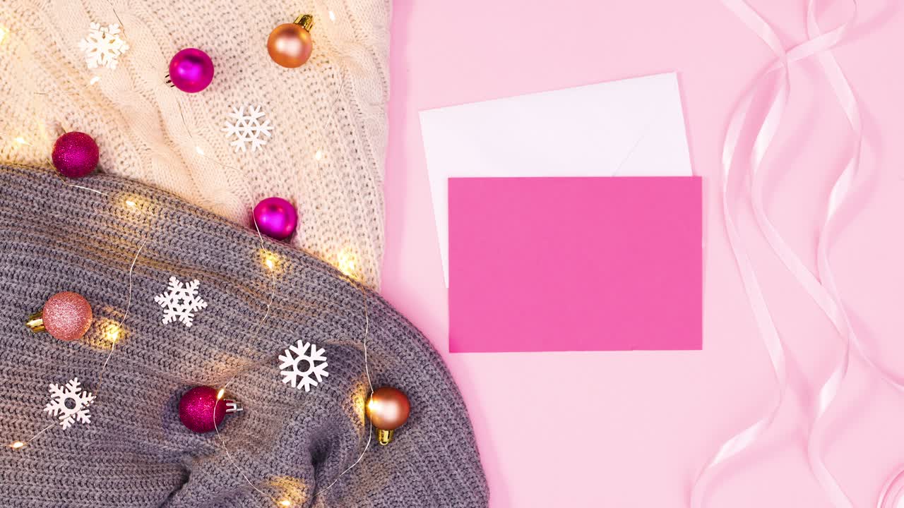 papel rosa y sobre para los deseos de navidad y luces parpadeantes en ropa de punto.