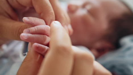 la pequeña mano del bebé en las manos de los padres