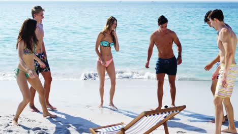 amigos jugando al fútbol en la playa
