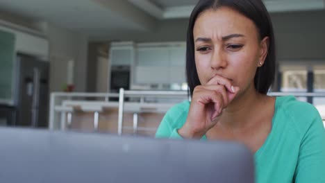 mujer afroamericana usando una computadora portátil mientras trabaja desde casa
