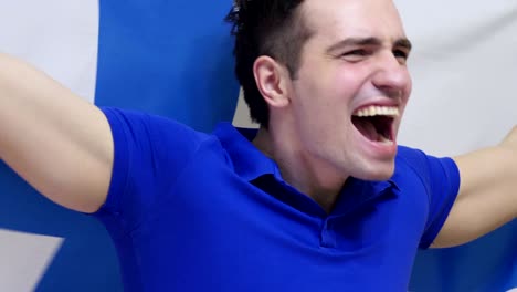 joven finlandés celebrando mientras sostiene la bandera de finlandia en cámara lenta