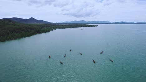 Barcos-De-Cola-Larga-En-Las-Aguas-De-La-Bahía-De-Phang-Nga-En-Tailandia-Con-Un-Dron-Aéreo-Elevándose-Y-Panorámica-Con-Vistas-Panorámicas