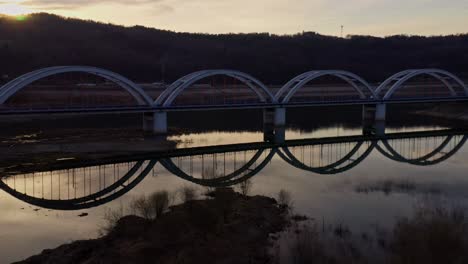 railway bridge on skawa river near lake mucharskie at dusk in poland