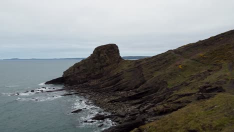 Pushing-Aerial-Drone-Towards-Rickets-Head-with-Coast-Path-and-Crashing-Waves-from-Atlantic-Ocean-in-Pembrokeshire-UK-4K