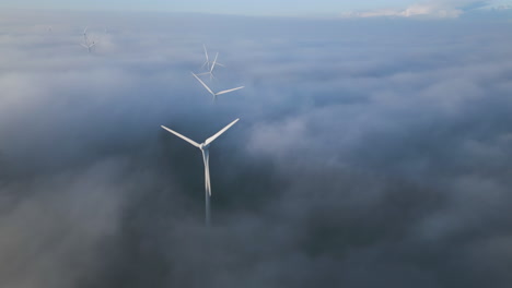 aerial revealing wind turbines above the clouds