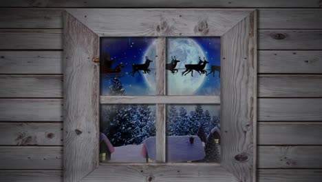 Wooden-window-frame-against-snow-falling-over-multiple-houses-and-trees-on-winter-landscape