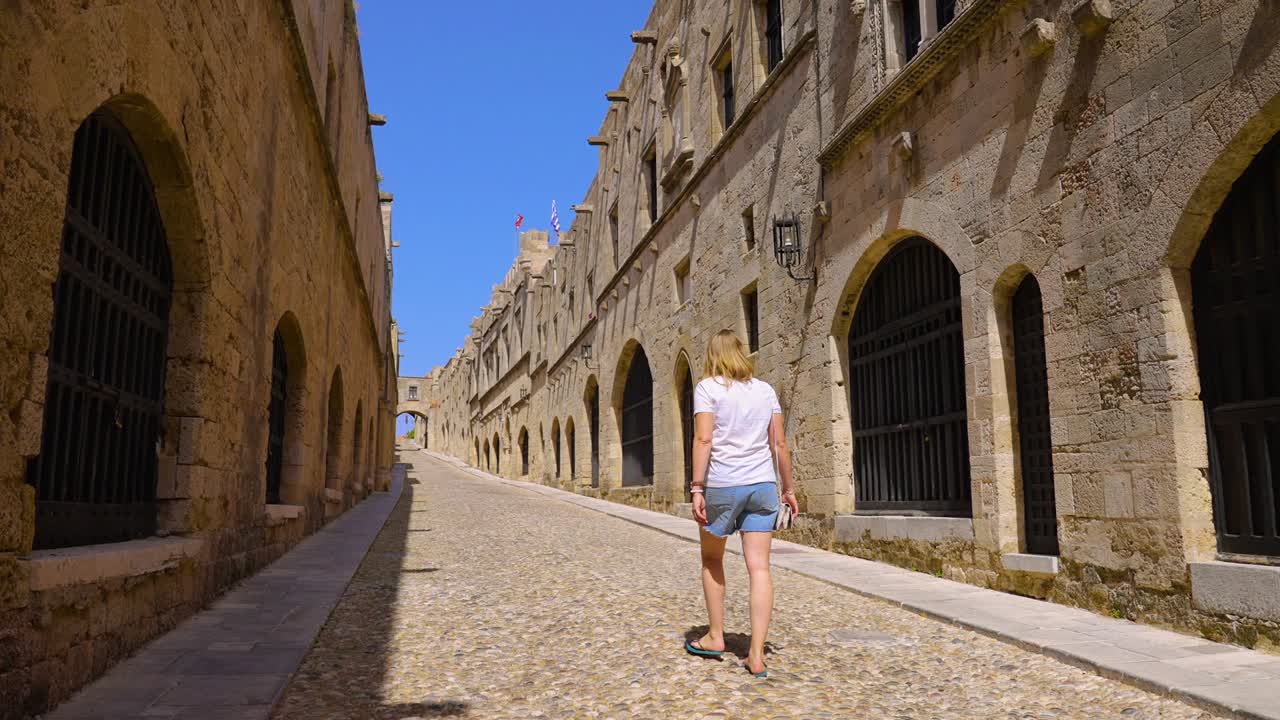 그리스 로데스 (rhodes) 의 옛 마을에 있는 그랜드 마스터 오브 나이트 스트리트 (grand master of the knights street) 에서 느린 속도로 고 있는 관광객을 따라가고 있다.