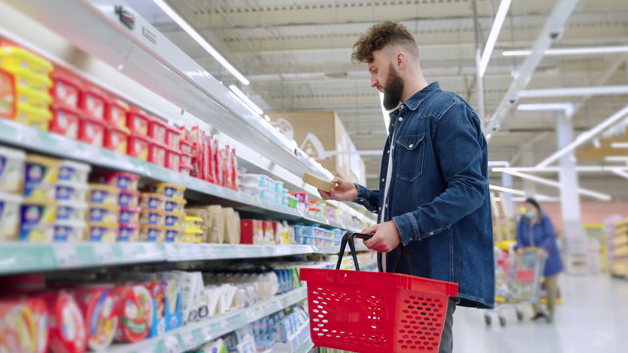 hombre comprando queso en la tienda de comestibles