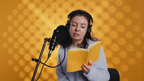 narrator wearing headset reading aloud from book into mic, studio background