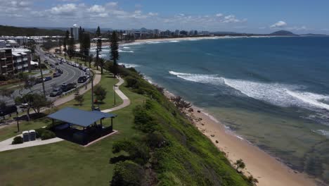 vista aérea de la costa y la playa con un pequeño pueblo al fondo