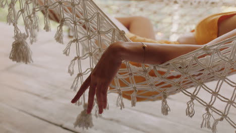 close up hand of woman in hammock sleeping comfortable lifestyle on holiday in vacation resort swaying peacefully on lazy summer day in tropical paradise cabin