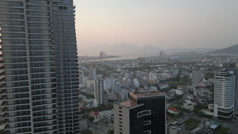hazy danang sunset in vietnam as drone passes skyscraper