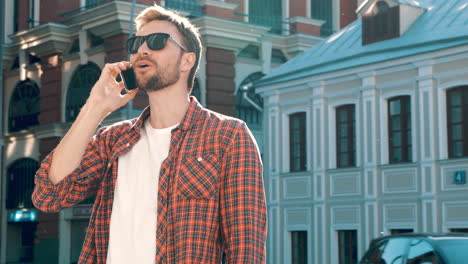 smiling man talking on phone in city street