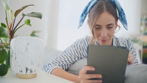 smiling woman learning online with digital tablet at home