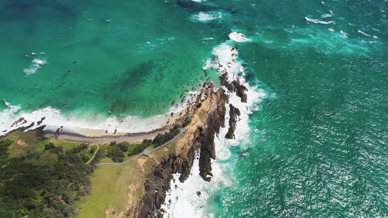 Aerial: Byron Bay and Coral Sea with turquoise water during the day in Byron Bay, New South Wales, Australia, top down drone shot