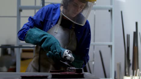 female welder using grinder in workshop 4k