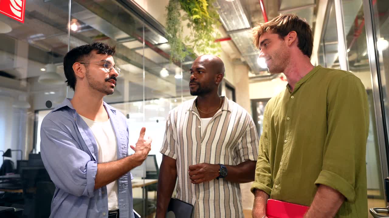 Diverse Colleagues Walking and Talking in a Modern Office Hallway