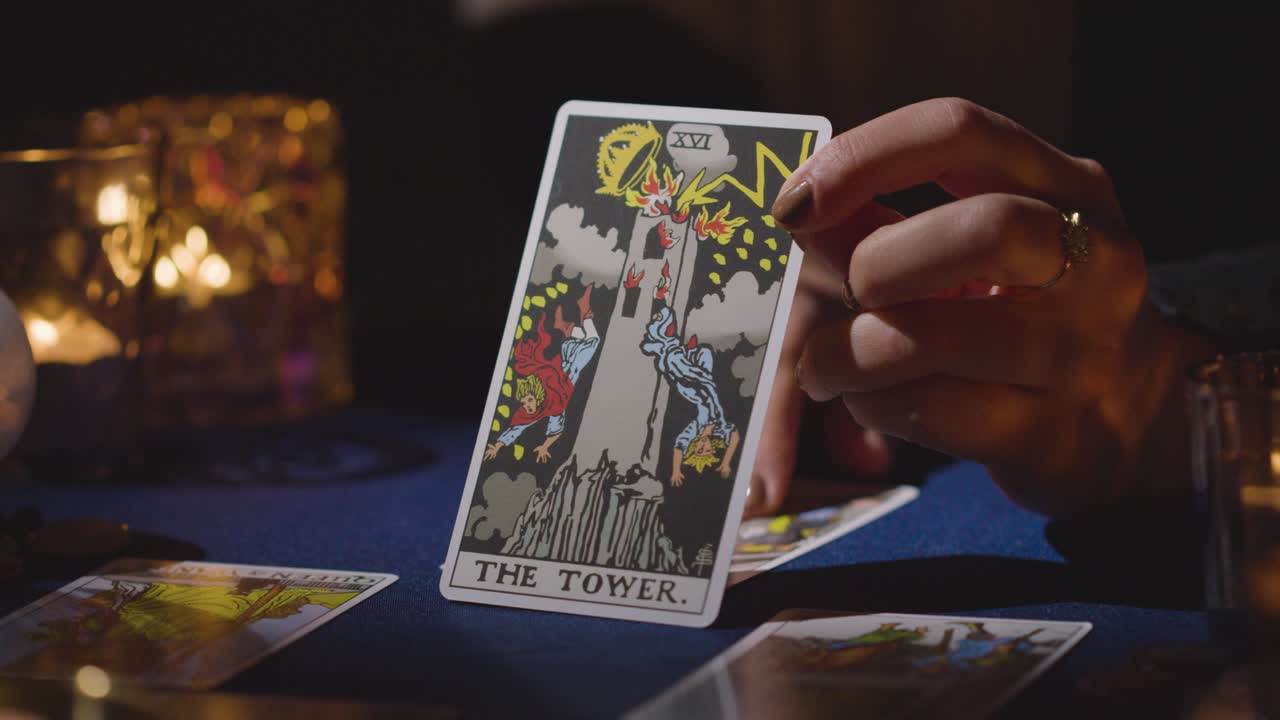 Close Up Of Woman Giving Tarot Card Reading On Candlelit Table Holding The Tower Card 5