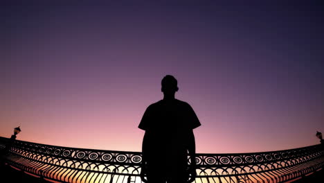 silhouette of a person at sunset bridge