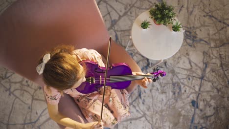 close-up of musician woman playing violin at home. composing, playing music.