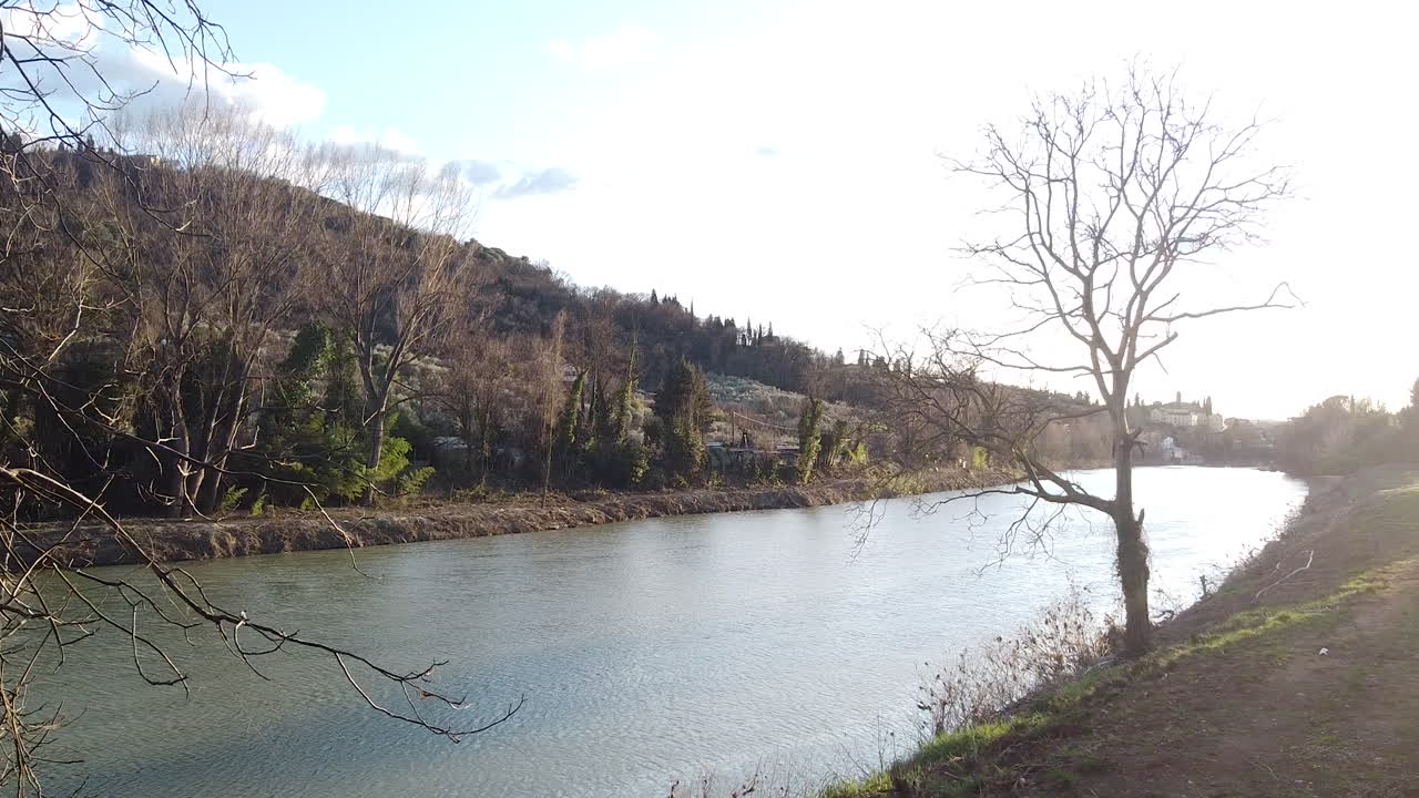 Winter Riverside flying in Sunset drone above the Arno river. Girone small town near Fiesole Florence, in the Tuscany region of Italy. December 2019