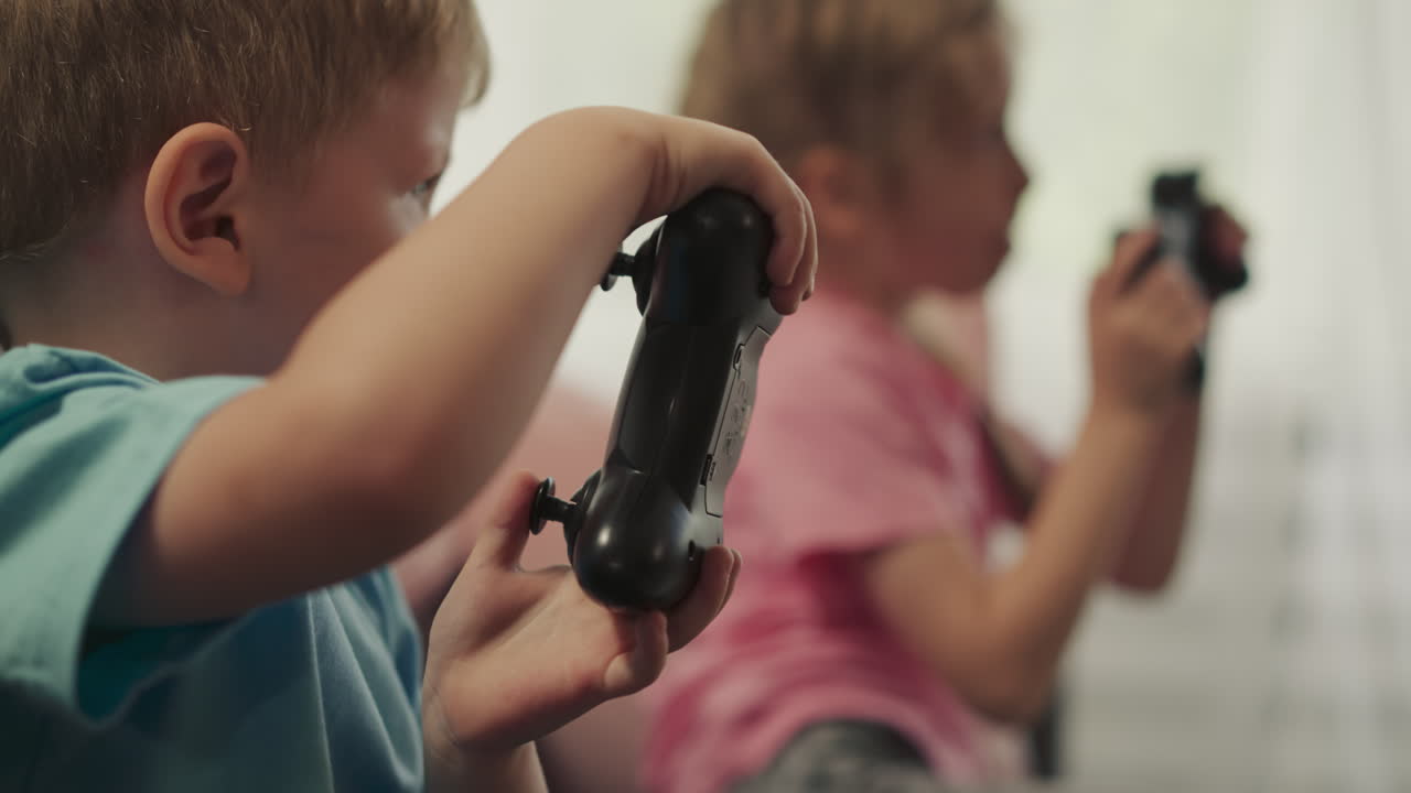 Toddler and preschooler control consoles playing video game