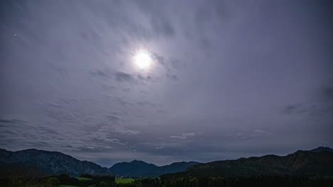 Timelapse-of-partially-obscured-sun-with-cloudy-sky-over-mountain-range,-22-degree-halo