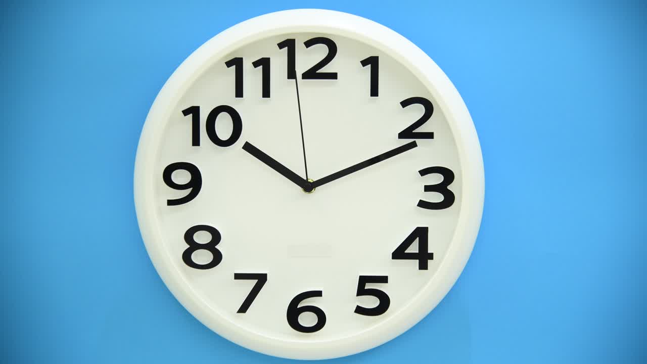 Orologio da parete bianco su sfondo blu.